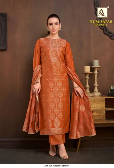 Alok Suit Humsafar Edition 6: Rust-orange salwar suit with gold zari work, straight-cut kurti, matching pants, and a coordinated printed dupatta.