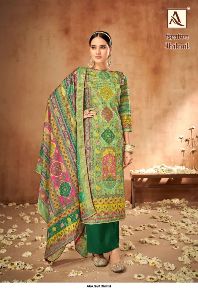 Alok Suit Jhilmil: A model wearing a green and multi-colored printed salwar suit with intricate patterns and a coordinating patterned dupatta.