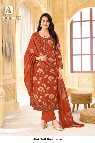Alok Suit Noor Luxe: Rust orange salwar suit with floral print, featuring intricate zari and thread work embroidery on the neckline and hemline.