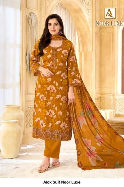 Alok Suit Noor Luxe: Mustard yellow salwar suit with floral print, featuring intricate zari and thread work embroidery on the neckline and hemline.