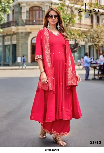 Clysi Zafira Vol 2043: Red salwar suit featuring a flared kurta, matching wide-leg pants, and a patterned dupatta with festive embellishments.