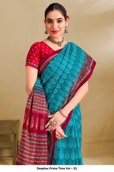 Deeptex Prime Time Vol – 21 teal and red printed cotton saree with a patterned border, styled with a red blouse.