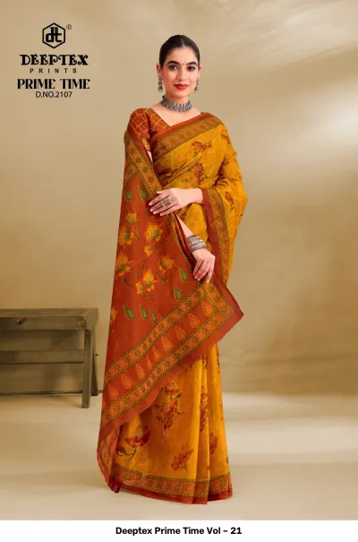 Deeptex Prime Time Vol – 21 mustard yellow and burnt orange printed cotton saree with floral designs and a printed border.