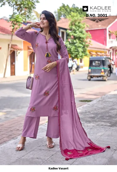 Kadlee Vasant Vol 3001, mauve salwar suit with floral thread work, tassels, and a matching dupatta with a wide embroidered border, worn outdoors.