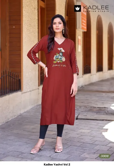 Kadlee Yashvi Vol 2: Maroon straight cut kurti with themed thread work embroidery and decorative hanging details on the chest.