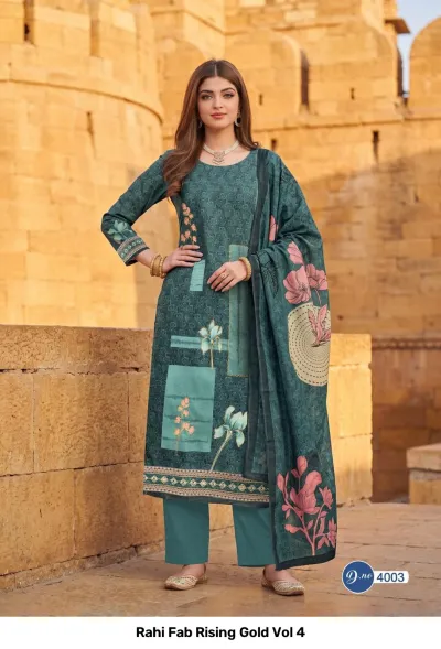 Rahi Fab Rising Gold Vol 4: Teal green salwar suit with floral prints and geometric block patterns, plus a matching printed dupatta.