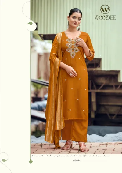 Woodee Raahi: Mustard yellow salwar suit with elaborate mirror and thread work on the chest, straight pants, and a metallic zari dupatta.