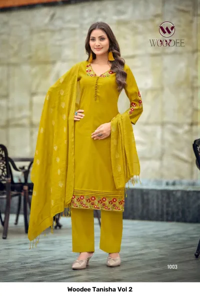 Woodee Tanisha Vol 2 mustard yellow salwar suit with floral embroidery at the neckline and hem, paired with matching pants and a dupatta.