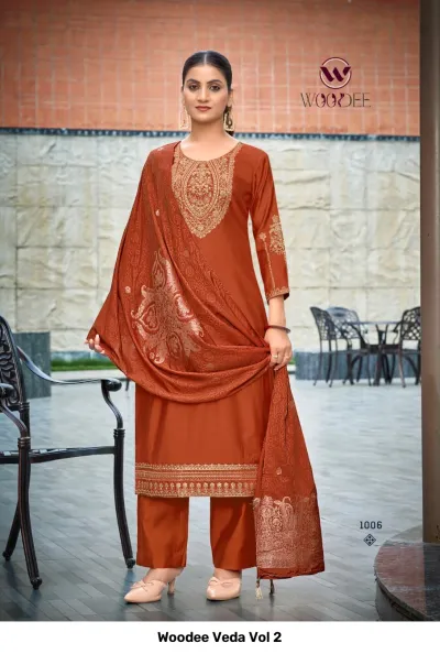 Woodee Veda Vol 2 rust orange salwar suit with matching trousers, dupatta, and intricate golden thread embroidery on neck and hem.