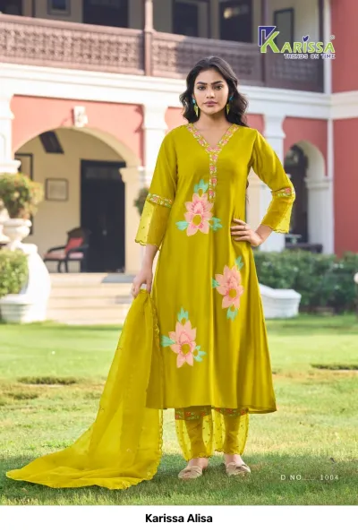 Karissa Alisa olive green salwar suit featuring large floral printed motifs, v-neckline, and matching dupatta, worn by a model outdoors.