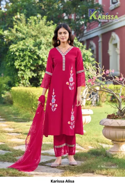 Karissa Alisa maroon salwar suit with floral prints, v-neck embroidery, and matching dupatta, worn by a model in an outdoor setting.