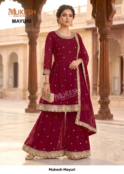 Mukesh Mayuri: A maroon sharara salwar suit with gold zari detailing, featuring a pleated kurta and embellished dupatta.