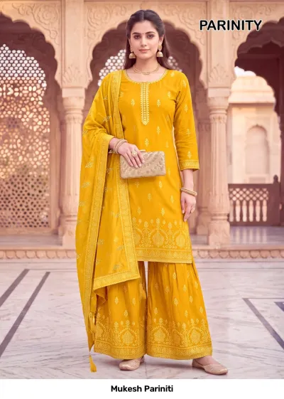 Mukesh Pariniti mustard yellow salwar suit with a kurta, sharara, and dupatta featuring intricate gold printed motifs and zari detailing.