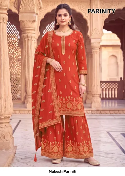 Mukesh Pariniti burnt orange salwar suit with a printed kurta, sharara, and matching dupatta featuring gold zari embroidery.
