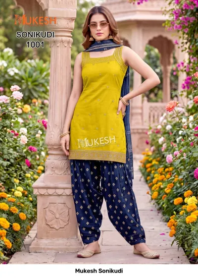Mukesh Sonikudi 1001, mustard yellow kurti with gold embroidery, paired with a blue printed salwar and matching dupatta.