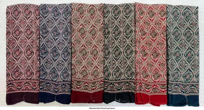 Wholesale Ajrak Printed Crepe Sarees: Five folded sarees with repeating decorative geometric Ajrak patterns in various colors.