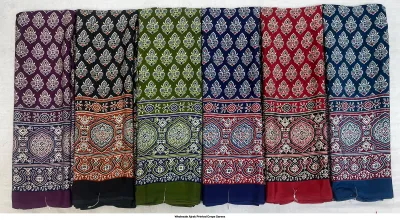 Wholesale Ajrak Printed Crepe Sarees: Six folded sarees in vibrant colors with repetitive leaf Ajrak block prints.
