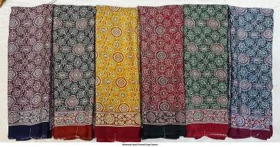 Wholesale Ajrak Printed Crepe Sarees: Six colorful folded sarees with intricate circular floral Ajrak block prints.