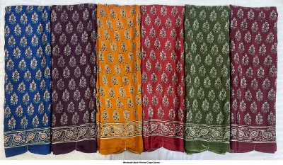 Wholesale Ajrak Printed Crepe Sarees: Five folded sarees in assorted colors with repeating geometric Ajrak patterns.