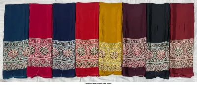 Wholesale Ajrak Printed Crepe Sarees: Six folded sarees in vibrant colors with repeating small floral Ajrak prints.