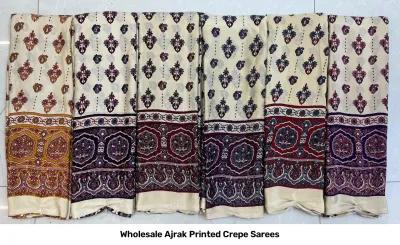 Wholesale Ajrak Printed Crepe Sarees: Seven folded sarees in multiple colors with repetitive floral Ajrak block prints.