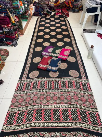 Wholesale Ajrak Printed Crepe Sarees: Catalog layout displaying a black saree with large circular and floral Ajrak prints and fabric samples.