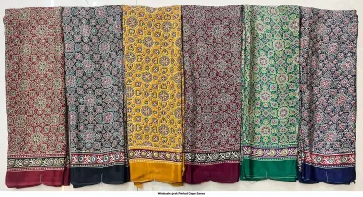 Wholesale Ajrak Printed Crepe Sarees: Six colorful folded sarees with repetitive floral Ajrak block print motifs.