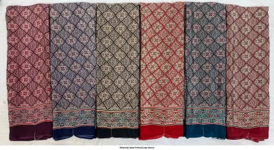 Wholesale Ajrak Printed Crepe Sarees: Six folded sarees in assorted colors with ornate geometric Ajrak block print.
