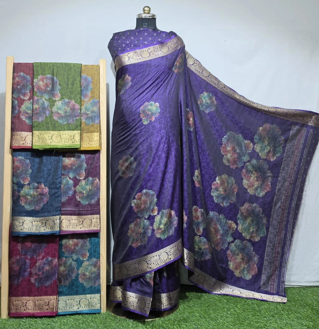 Wholesale Black Jacquard Silk Sarees: Purple floral print saree with gold zari work border, displayed on mannequin with assorted color variations on rack.