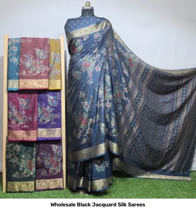 Wholesale Black Jacquard Silk Sarees: Blue floral print saree with gold zari border, displayed on mannequin with assorted color variations on rack.