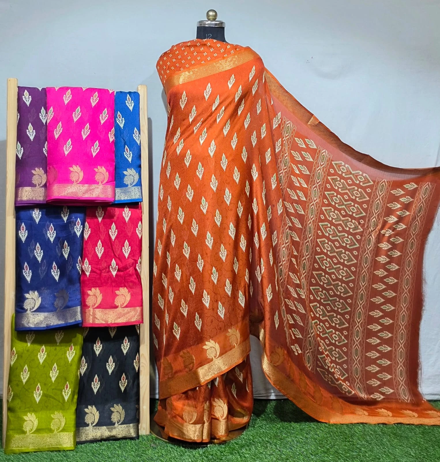 Wholesale Digital Printed Self Jacquard Marsh Mellow Sarees: Orange saree featuring a geometric diamond-shaped print pattern and a wide metallic zari border.