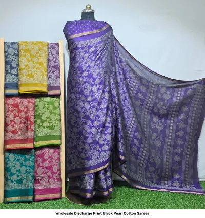 Wholesale Discharge Print Black Pearl Cotton Sarees: A purple cotton saree featuring white floral discharge prints and a gold zari border.